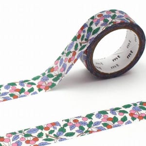 May include: A roll of decorative washi tape with a pattern of pink and red cherries, green leaves, and blue leaves on a white background. The tape is labelled with the letters "mt".