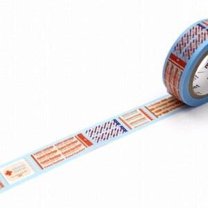 Könnte beinhalten: Eine Rolle dekoratives Washi-Tape mit einem hellblauen Kern und einem Muster aus roten, orangefarbenen und blauen Rechtecken. Das Klebeband hat einen hellblauen Hintergrund mit Text und grafischen Designs.