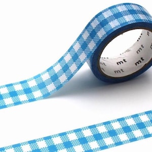 Könnte beinhalten: Eine Rolle blau-weiß kariertes Washi-Tape. Das Klebeband ist abgerollt und zeigt das Muster. Das Klebeband ist mit den Buchstaben "mt" beschriftet. Der Hintergrund ist weiß.