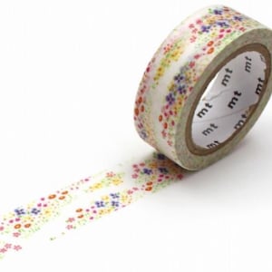 May include: A roll of decorative washi tape with a floral pattern. The tape features small flowers in shades of pink, yellow, and blue on a white background. The tape is partially unrolled, revealing the floral design.