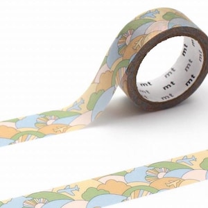 May include: A roll of decorative washi tape with a repeating pattern of airplanes, clouds, and suns in pastel colours. The tape is tan with blue, green, and yellow accents. The tape is labelled with the letters "mt".