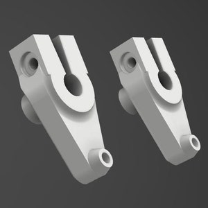 May include: Two white plastic parts with a U-shaped opening and a small hole on the side. The parts are designed to be connected together.