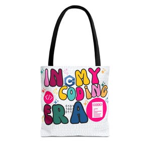 Op de afbeelding: Witte tote bag met zwarte handvatten. De tas heeft de tekst "IN MY CODING ERA" in kleurrijke bubbelletters, samen met codeersymbolen en een binair codepatroon, ideaal voor programmeurs.