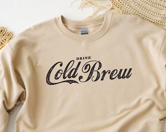 Sudadera unisex con cuello redondo y estampado gráfico Cold Brew, color arena