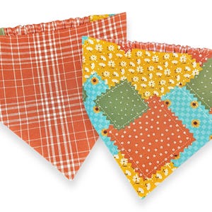 May include: Two colorful pet bandanas. One is orange plaid, the other is a patchwork design with orange polka dots, green squares, yellow floral, and blue sunflower patterns. Both have a gathered top edge.