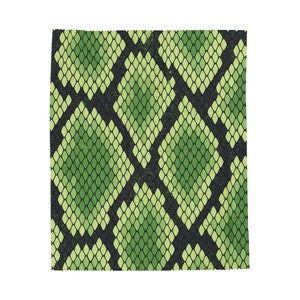 May include: A green and black patterned textile with a snake skin design. The pattern features diamond shapes in varying shades of green, outlined in black. The textile has a textured appearance.