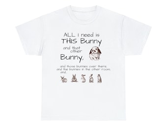 Puede incluir: Camiseta blanca con una ilustración de un conejo marrón y el texto "ALL I need is THIS Bunny and that other Bunny, and those bunnies over there, and the bunnies in the other room and..."