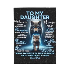 Op de afbeelding: Een zwart en blauwe deken met een wolf en wolfwelp ontwerp. De deken heeft een boodschap aan een dochter van haar vader, die zegt "To My Daughter" en "Love Dad".