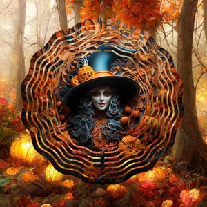 May include: A metal wind spinner with a witch wearing a blue and black hat and a long black dress. The background is a forest with fall foliage and pumpkins.