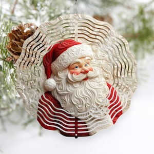 May include: A red and white metal wind spinner featuring a smiling Santa Claus with a white beard and red hat. The spinner has a swirling design with multiple layers.