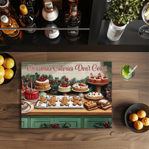 May include: A canvas print with the text "Christmas Calories Don't Count" features a festive display of cakes, gingerbread men, and desserts. The scene includes a variety of baked goods, including layered cakes with cherries, and gingerbread cookies, set against a green counter.