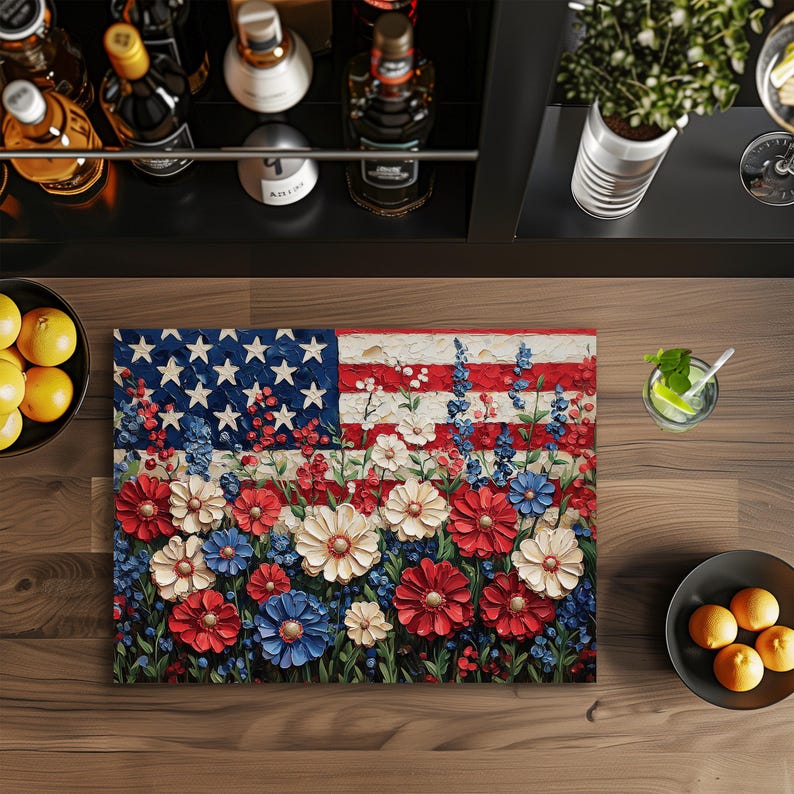 Puede incluir: Una pintura floral de la bandera estadounidense. La obra de arte presenta un campo de flores rojas, blancas y azules en lugar de las rayas y estrellas de la bandera. Las flores est&aacute;n en varias etapas de floraci&oacute;n, creando un efecto texturizado y tridimensional.