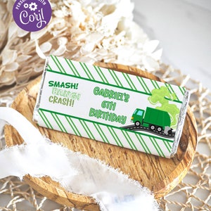 Może przedstawiać: Opakowanie na tabliczkę czekolady w zielono-białe paski z zielonym śmieciarzem i tekstem "Smash! Bang! Crash! Gabriel's 6th Birthday".