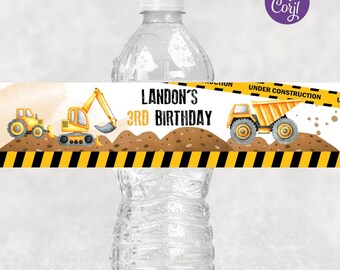 May include: A printable water bottle label featuring a construction theme. The label has a yellow and black striped border with a yellow excavator and dump truck on a brown dirt background. The text on the label reads "LANDON'S 3RD BIRTHDAY".