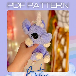 Può includere: Uno schema all'uncinetto per un giocattolo amigurumi unicorno viola e bianco chiamato "Bitsy". Lo schema è disponibile per il download in PDF.
