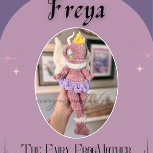 May include: A crocheted fairy doll named Freya, in a soft pink hue, with a lavender skirt and white accents. The doll has large eyes and a yellow crown. The text "The Fairy FrogMother" is below the doll.