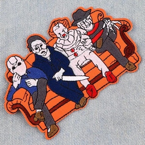May include: An embroidered patch featuring four horror movie characters sitting on an orange couch. The characters include a clown, a man with a hockey mask, a man with a Freddy Krueger-style glove, and a man with a knife. The patch is perfect for adding a spooky touch to any project.