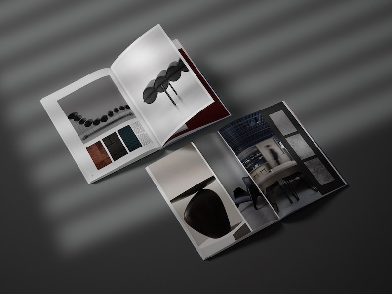 May include: Two open magazines displaying interior design imagery. One shows black spheres, a colour palette, and a design element. The other features a minimalist interior with a table and chairs.