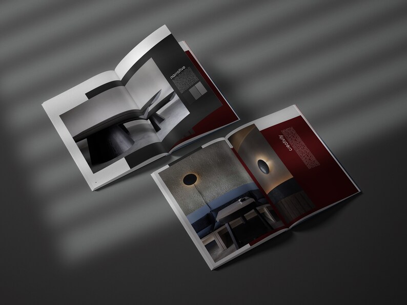 May include: Two open magazines displaying interior design photography. One spread shows a monochrome image of a table and the word "narrative". The other spread has a dark red background with the word "creativity".