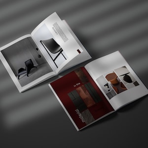 May include: Two open magazines with interior design images. One magazine features a black chair and the word "Creativity". The other magazine has the text "is the material" and images of wood and furniture.