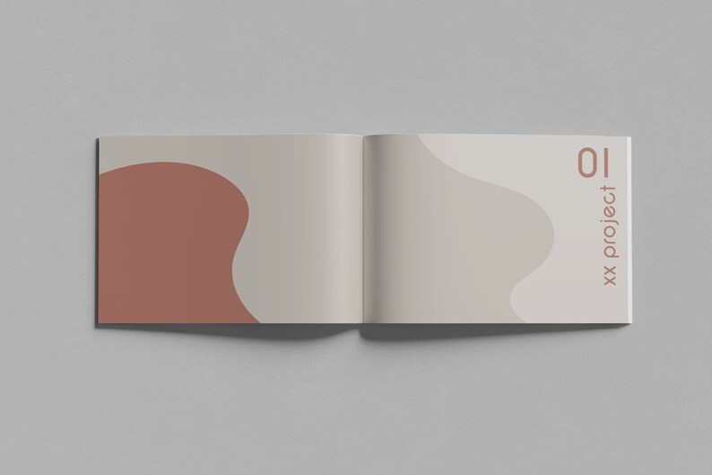 K&ouml;nnte beinhalten: Ein ge&ouml;ffnetes Buch mit einem beigefarbenen Einband und einem braunen abstrakten Design. Der Text "01 xx project" ist auf der rechten Seite gedruckt.