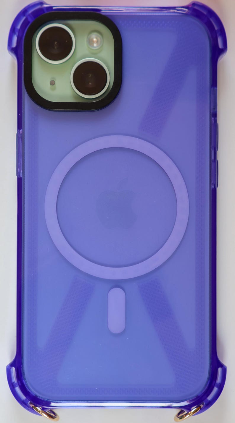 May include: A purple clear phone case with a built-in ring holder and a gold metal strap. The case has a textured design.