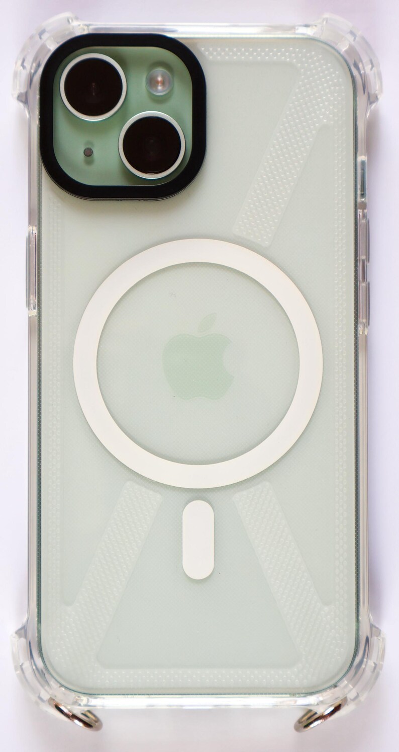 May include: A clear phone case with a white ring on the back. The ring has a white Apple logo in the center. The case has a textured pattern.