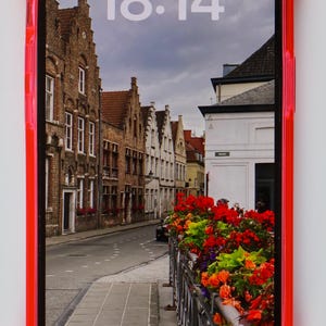May include: A red phone case with a clear back showing a phone screen with a photo of a street in a European city. The time on the screen is 18:14. The date is Sunday, September 1.