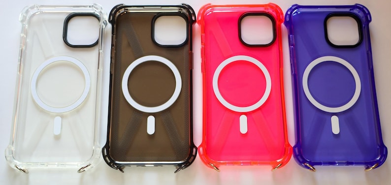 May include: Four phone cases with a white ring on the back. The cases are clear, black, pink, and purple.