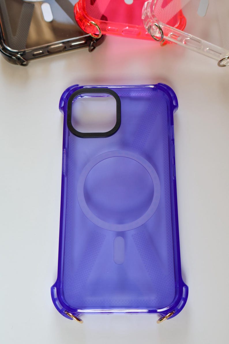 May include: A clear purple phone case with a ring holder and gold accents. The case has a textured design and is made of a durable material.