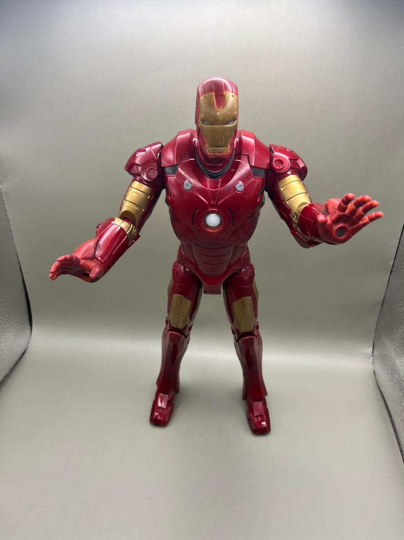 May include: Red and gold Iron Man action figure with a light-up chest. The figure is posed with arms outstretched, as if in a superhero stance.