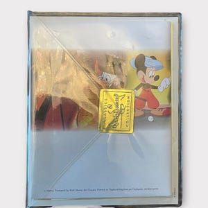 May include: Sealed Disney Classics framed art print featuring Mickey Mouse playing golf. The artwork includes Donald Duck and a gold foil sticker that reads "Disney Classics Collection". The print is in a clear plastic case.