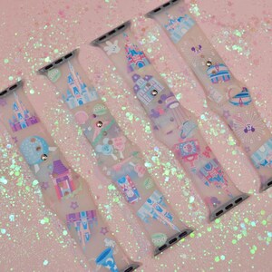 May include: Four clear silicone Apple Watch bands with a pastel pink, blue, and purple print of Disney castles and other icons.