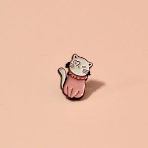 K&ouml;nnte beinhalten: Eine Emaille-Anstecknadel mit einem Cartoon-Katzenmotiv, das ein rosa Kleid tr&auml;gt. Die Katze zwinkert und hat ein herzf&ouml;rmiges Auge.