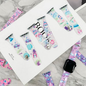 May include: A set of clear, colorful, silicone Apple Watch bands with a Disney castle and other theme park designs. The bands are on a white surface with the text "XK-12 MADE IN CHINA".