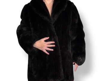 May include: A long, black faux fur coat with a wide collar. The coat has a classic design and a soft, plush texture. The coat is knee-length and has long sleeves.