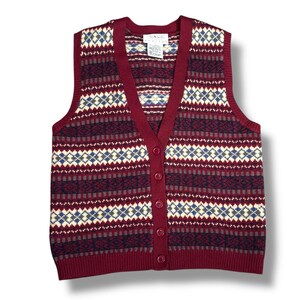Puede incluir: Un chaleco de punto abotonado burdeos con cuello en V y un diseño estampado. El patrón incluye rayas horizontales y rombos en crema, azul marino y gris. El chaleco tiene una etiqueta que dice "Talbots Petites".