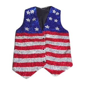 May include: A sequined vest featuring the American flag design. The top portion is blue with white stars, and the bottom has red and silver stripes. The vest has a black lining and a button-up front.