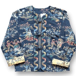 May include: A dark blue jacket with a colorful pastoral scene print. The jacket features a mandarin collar, long sleeves, and decorative frog closures. The cuffs and trim have a cream-colored floral pattern.
