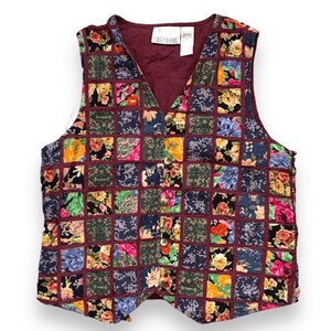 May include: A vintage vest with a patchwork design. The vest features a V-neck and a button closure. The patchwork squares are in various colors, including burgundy, green, yellow, and pink, with floral patterns. The tag reads "CASEY & MAX".