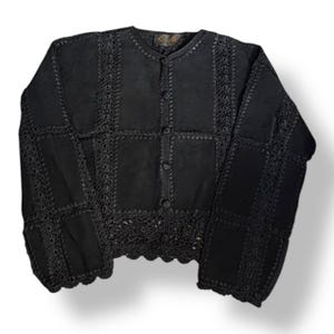 May include: Black crocheted cardigan with a button-up front and a scalloped hem.