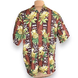 Peut inclure: Une chemise à manches courtes marron avec un motif d'ananas et géométrique.