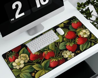 May include: A black and green mousepad with a repeating pattern of red strawberries and green leaves. The mousepad is on a white desk with a computer monitor and keyboard.