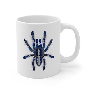 May include: White ceramic coffee mug with a blue and white tarantula spider printed on the front.