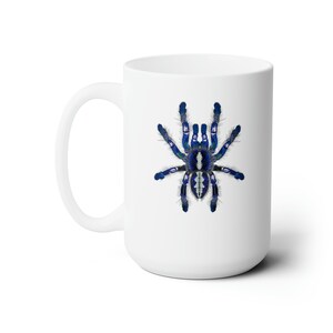 May include: White ceramic mug with a blue and white tarantula spider design.