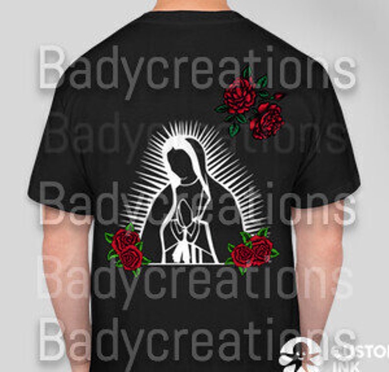 May include: Black t-shirt featuring a white graphic of the Virgin Mary with a halo and red roses. The design is centered on the back of the shirt. The text "Badycreations" is repeated vertically on the shirt.