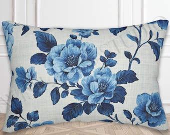 May include: Rectangular throw pillow featuring a blue floral pattern on a cream background. The design includes large, detailed blue flowers and leaves, creating a classic, elegant aesthetic. The pillow is placed on a wooden floor.