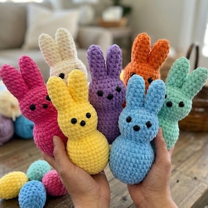 Puede incluir: Colección de conejitos de ganchillo hechos a mano en varios colores, incluyendo rosa, amarillo, morado, naranja, azul, blanco y verde. Cada conejito tiene ojos de botón negros. Decoración temática de Pascua.