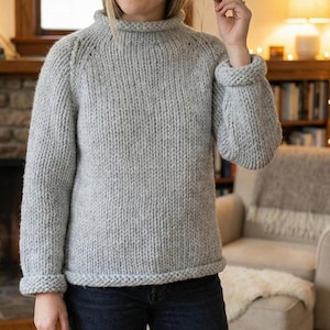 K&ouml;nnte beinhalten: Ein hellgrauer, grob gestrickter Pullover mit Rollkragen und gerippten B&uuml;ndchen. Der Pullover hat eine lockere Passform und ein dickes, strukturiertes Aussehen. Die &Auml;rmel sind lang und der Saum ist ebenfalls gerippt. Der Pullover besteht aus einem weichen, warmen Material.