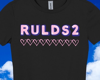 May include: Black t-shirt with the text "RULDS2" in pink and blue, with a row of pink hearts below. The shirt is a crew neck style.